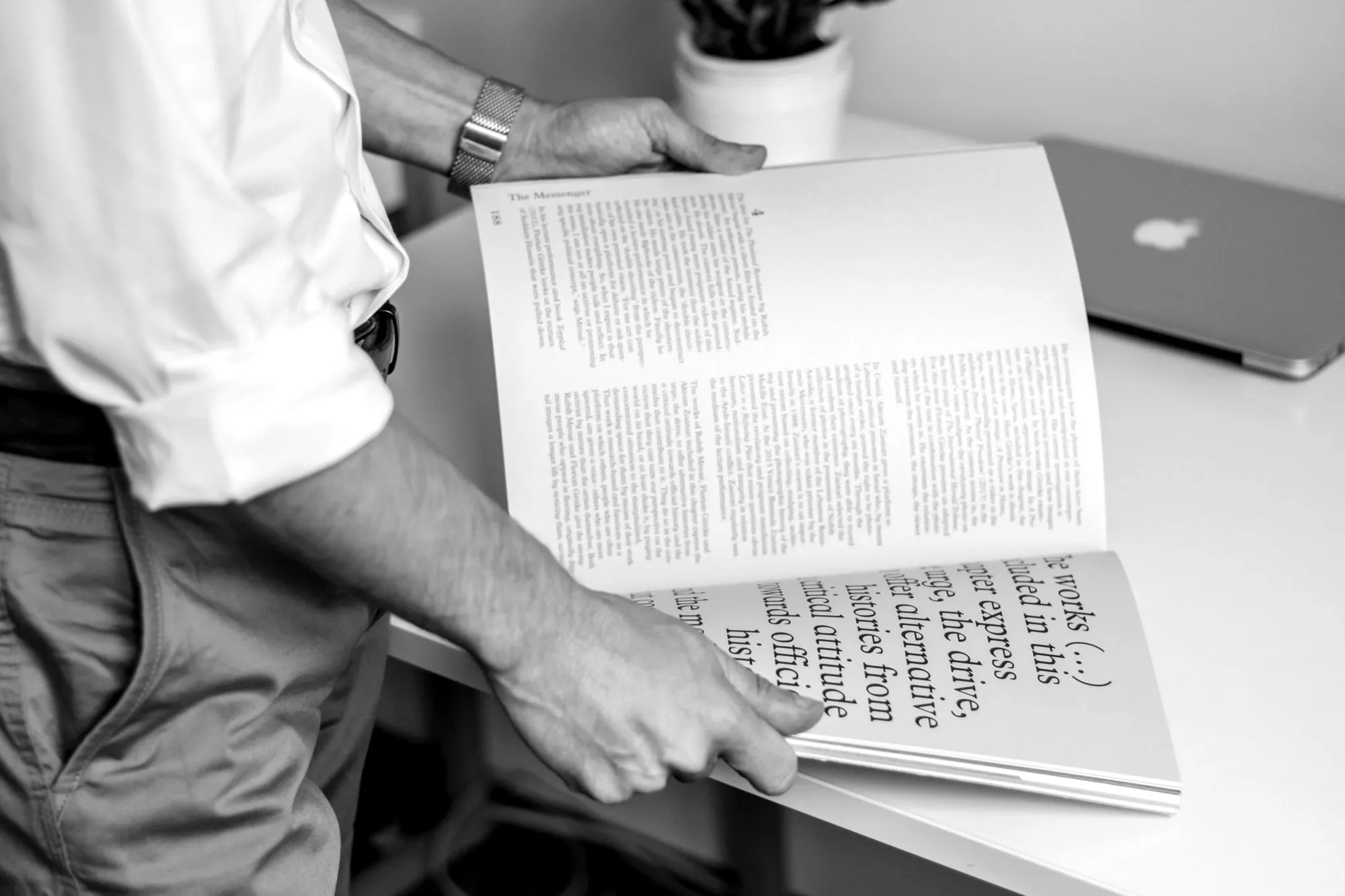 Hands turning the pages of a printed editorial
