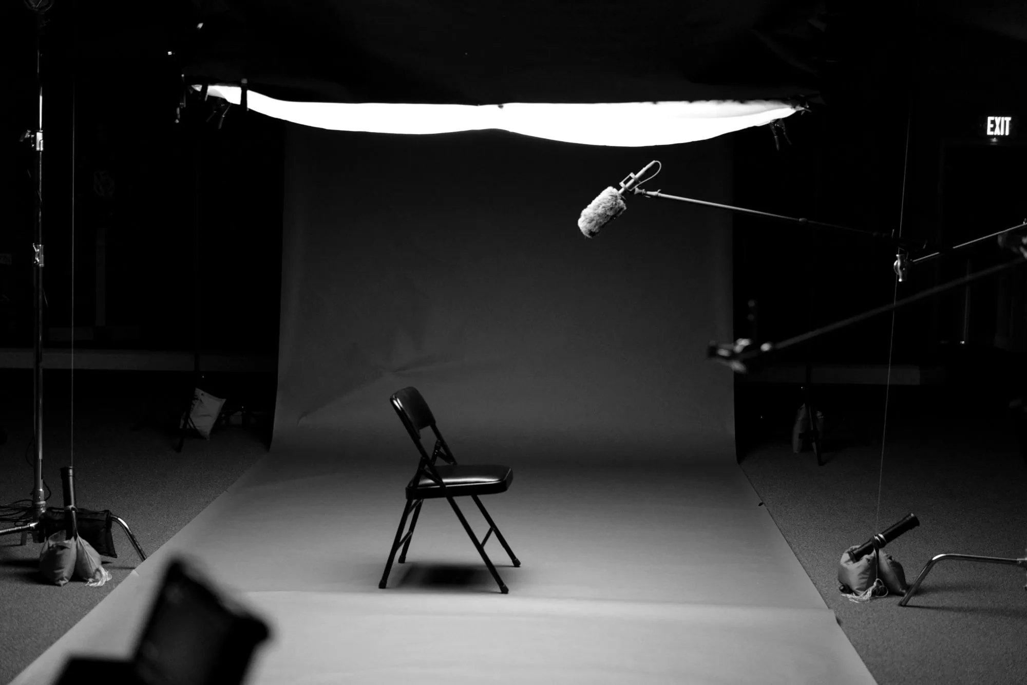 An empty chair on a lit studio set, waiting for the next interview